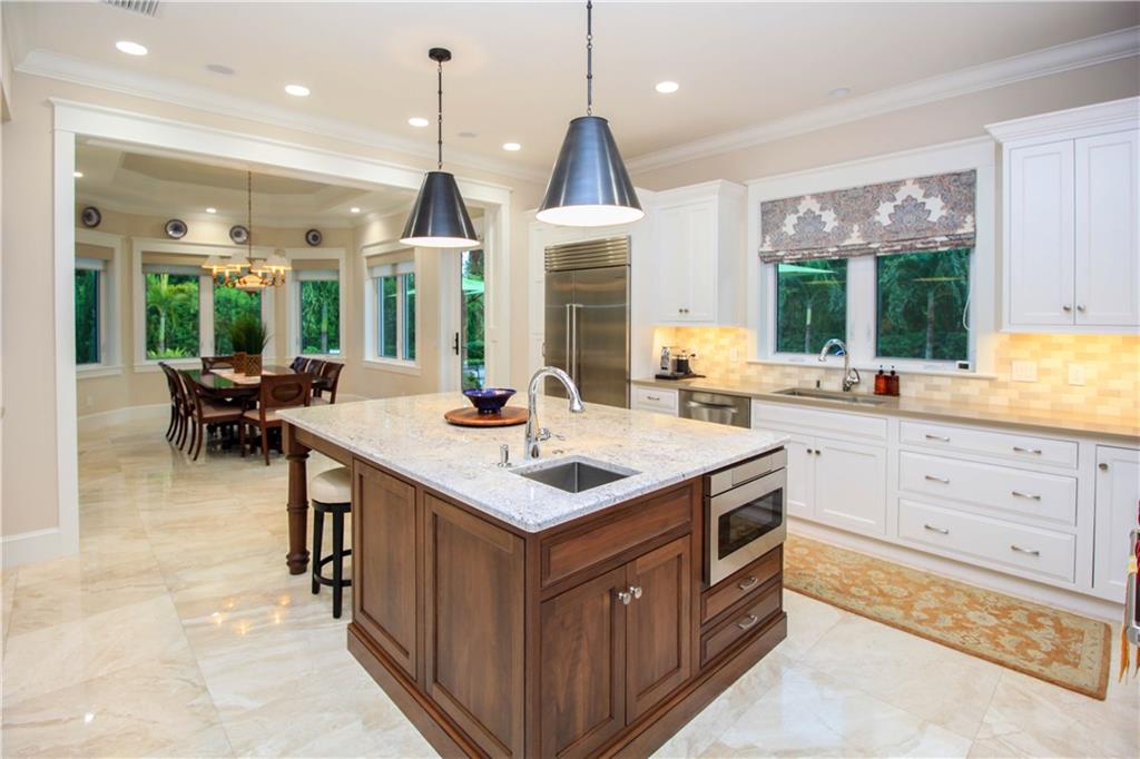 14 Middle Road Stuart, FL 34996 - Photo 10 of 33 a kitchen with kitchen island a sink dining table and chairs