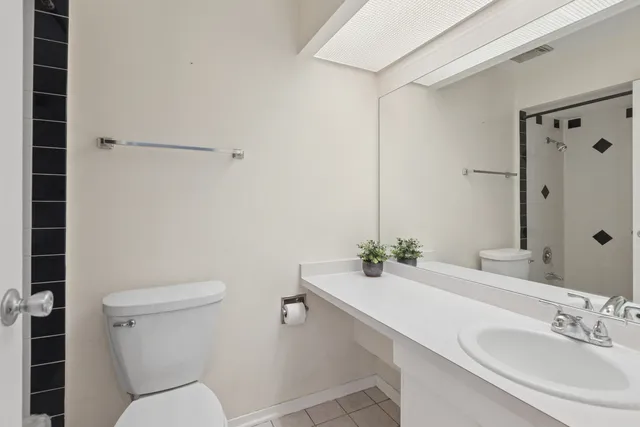 a bathroom with a sink mirror and toilet