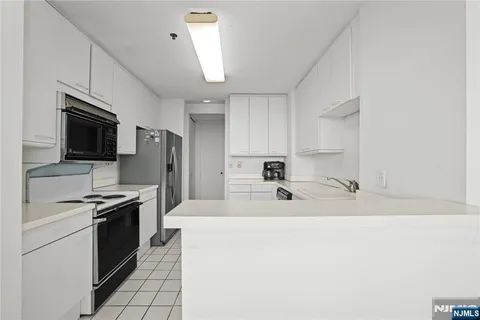 a kitchen with kitchen island a sink stainless steel appliances and cabinets