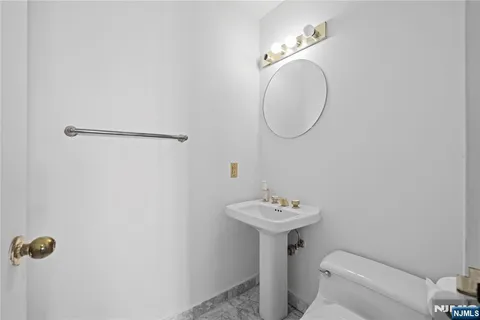 a bathroom with a sink toilet and a mirror
