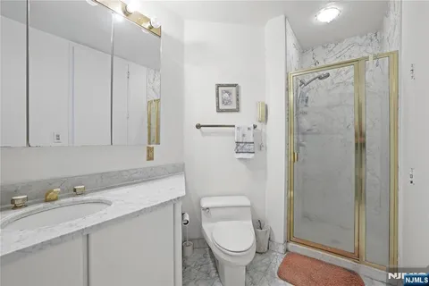 a bathroom with a granite countertop sink toilet and shower