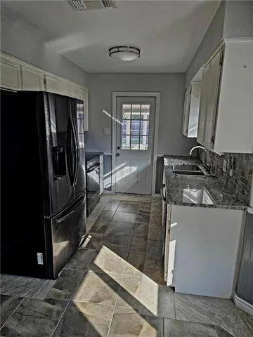 a kitchen with stainless steel appliances granite countertop a refrigerator a stove and a sink