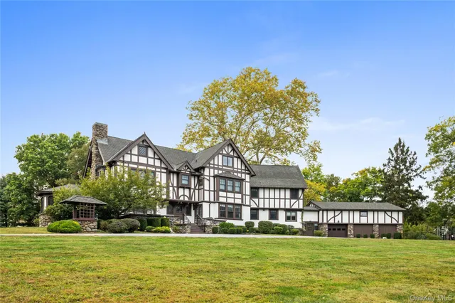 a view of a big house with a big yard and large trees