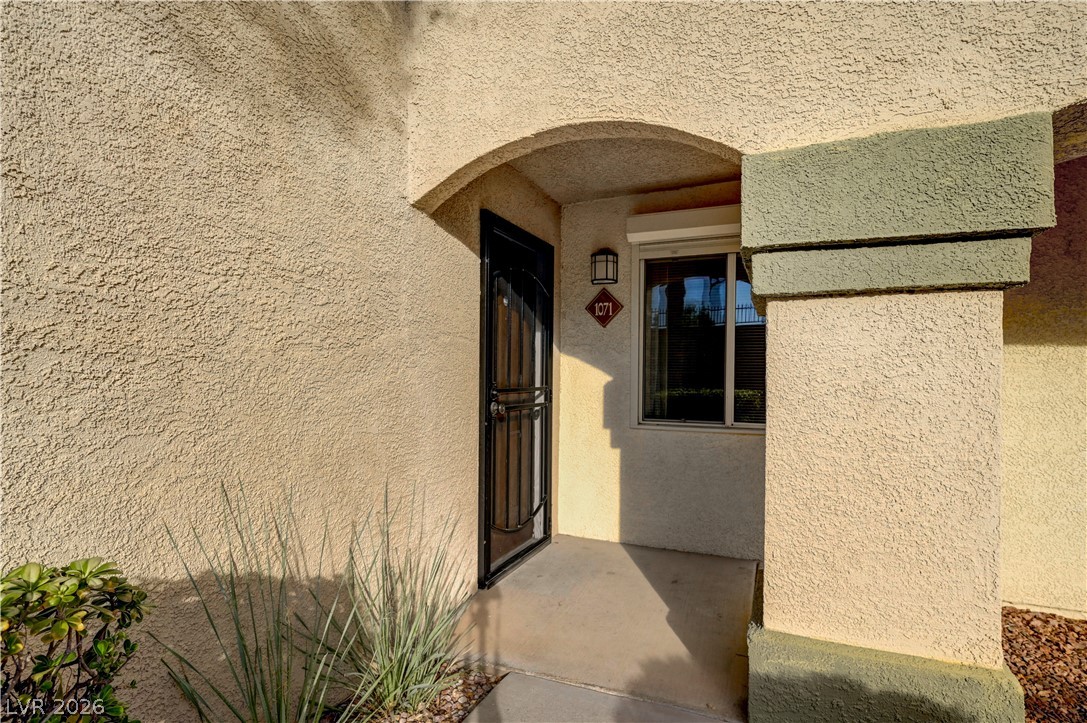 7885 West Flamingo Road, Unit 1071 Las Vegas, NV 89147 - Photo 5 of 28 An inviting entry framed by stucco textures and a robust security door.