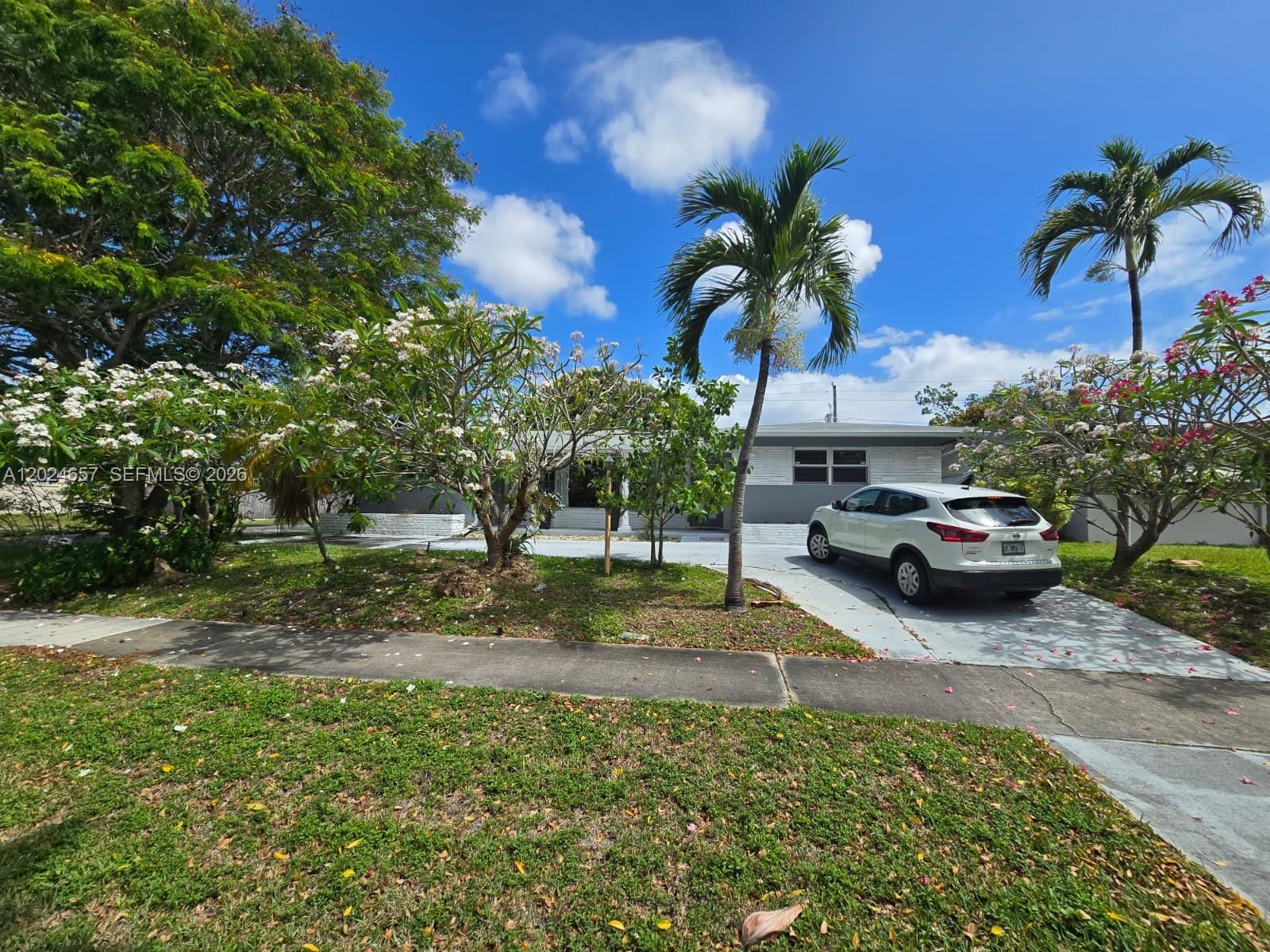 3619 West Park Road Hollywood, FL 33021 - Photo 2 of 19 a house with a garden and trees
