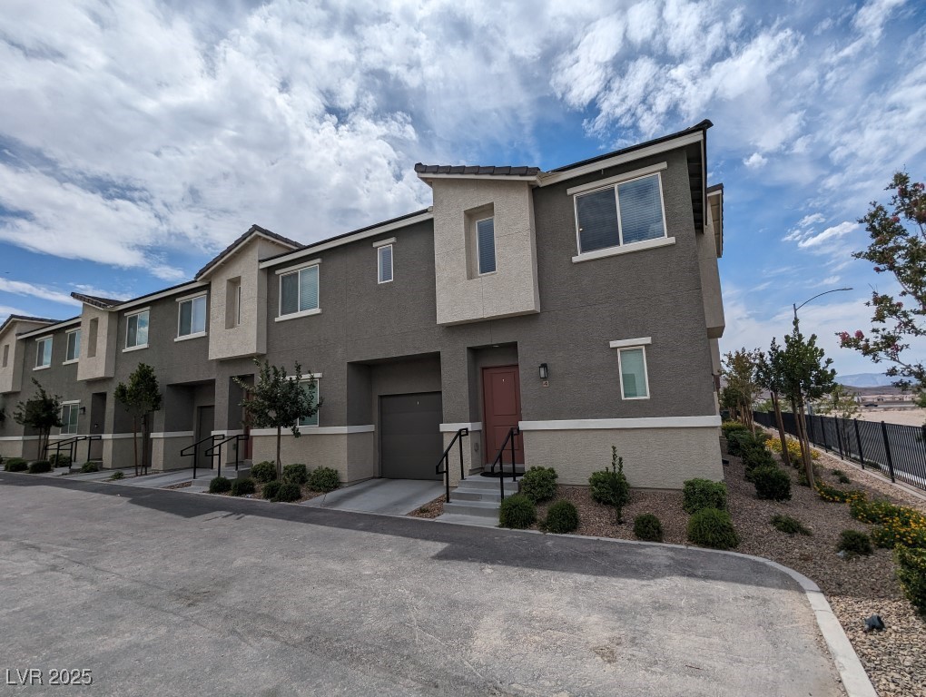 View of front of property featuring stucco siding and a garage