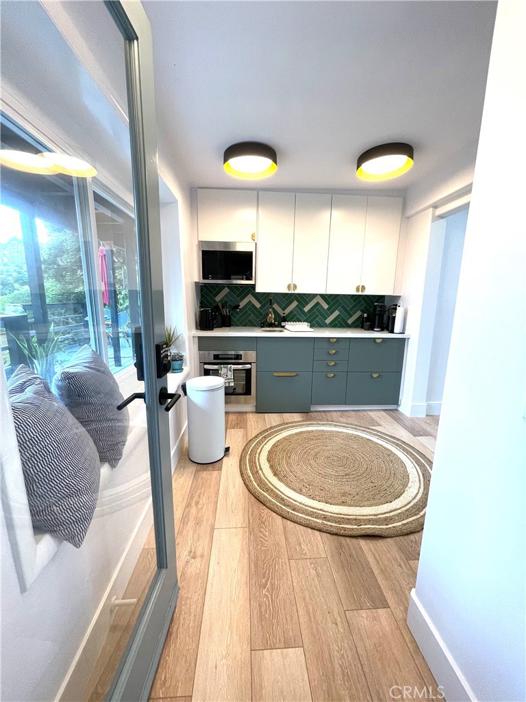 736 Griffith Place Laguna Beach, CA 92651 - Photo 8 of 31 a kitchen with stainless steel appliances granite countertop a sink a stove and a wooden floors