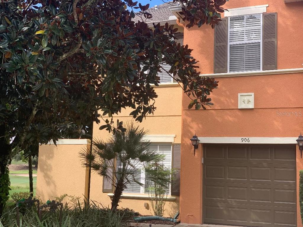 a front view of a house with a tree