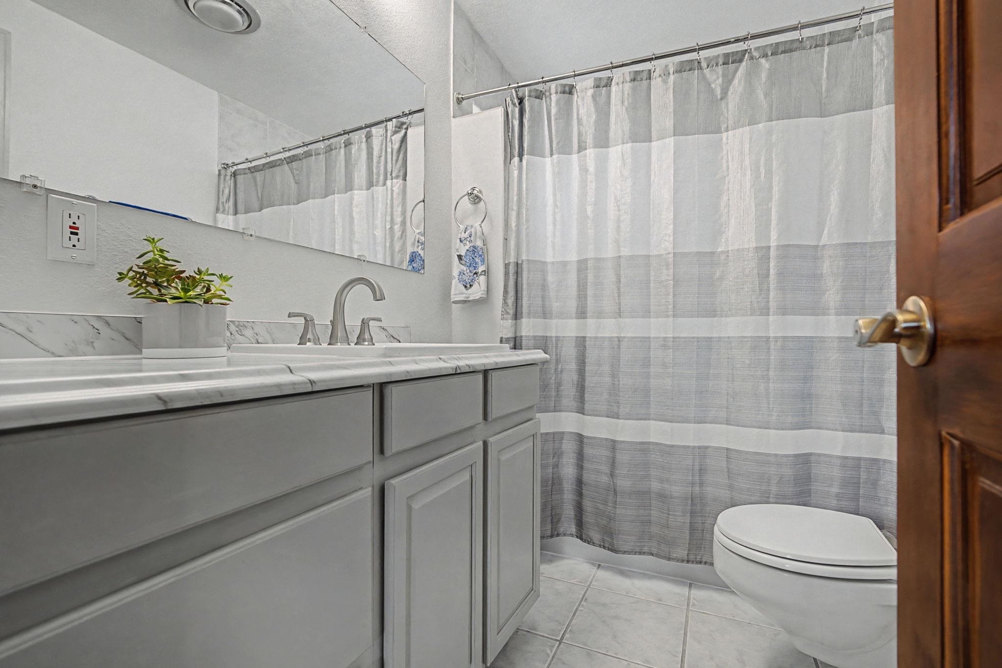 847 26 Road Grand Junction, CO 81505 - Photo 16 of 41 a bathroom with a granite countertop sink a toilet and shower