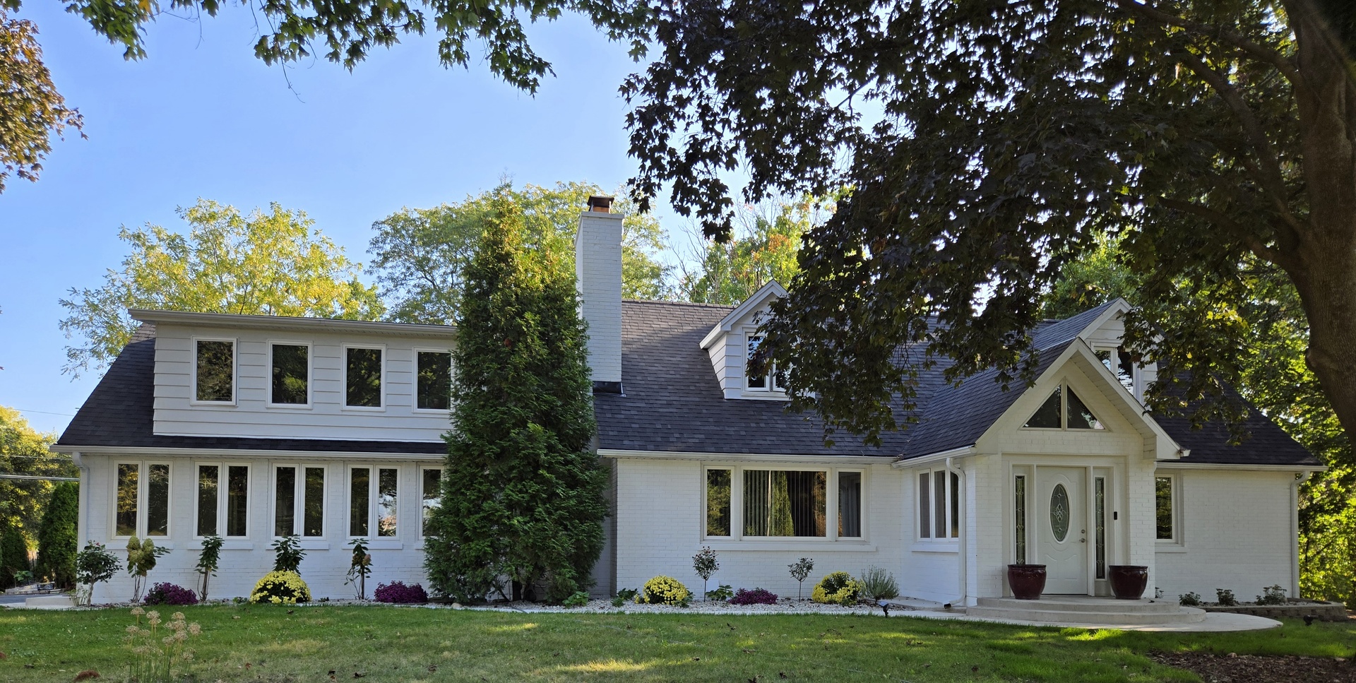 a front view of a house with a garden and yard