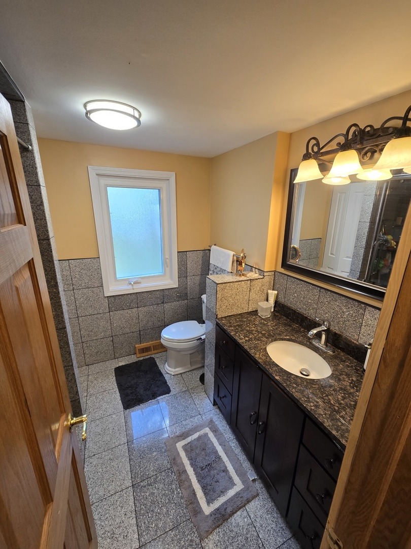 25W201 Summit Drive Naperville, IL 60563 - Photo 17 of 40 a bathroom with a granite countertop sink and a mirror