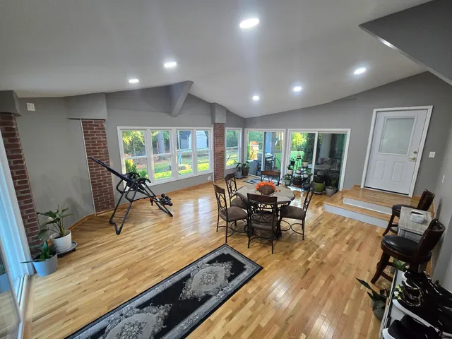 a living room with furniture a rug wooden floor and a large window