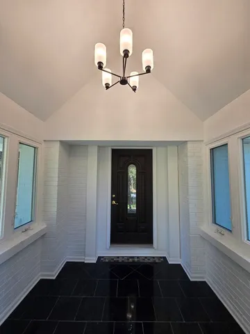a view of a hallway with wooden floor and a cabinet