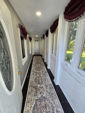 a view of a hallway with wooden floor and stairs