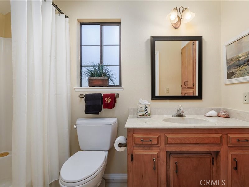 1912 Chester Lane Cambria, CA 93428 - Photo 24 of 41 a bathroom with a toilet a sink a mirror a window and vanity