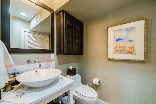 a bathroom with a sink a toilet and a mirror