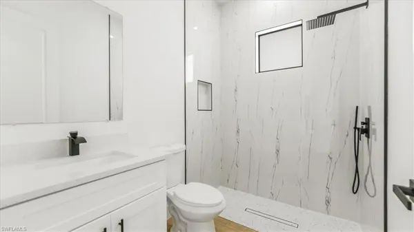 a bathroom with a sink a toilet and shower