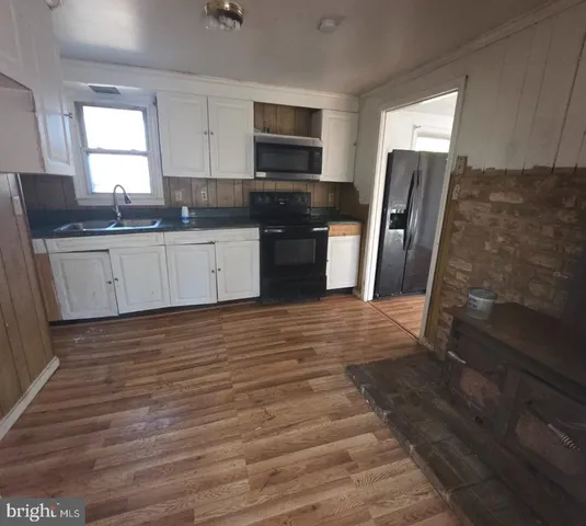 a kitchen with granite countertop a refrigerator sink and microwave