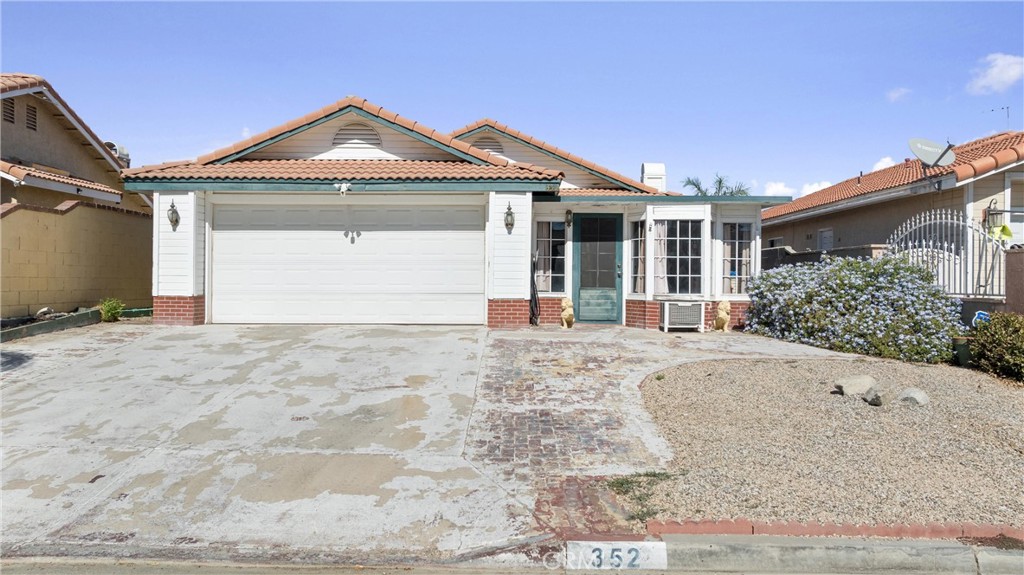 352 Red Spruce Place Perris, CA 92570 - Photo 26 of 30 a front view of a house with a yard and garage