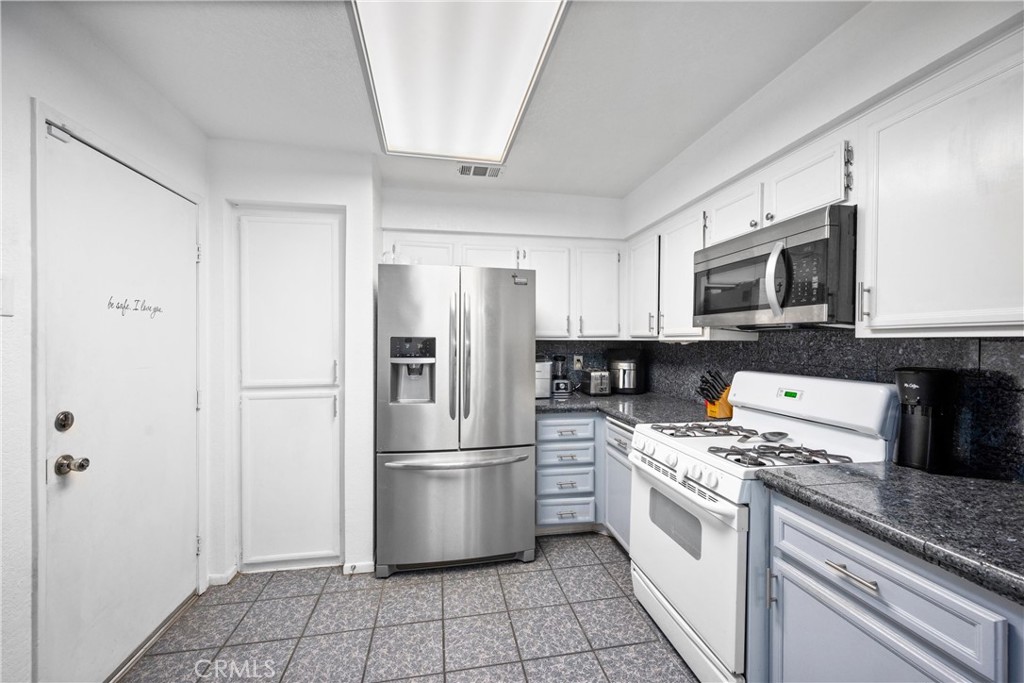 352 Red Spruce Place Perris, CA 92570 - Photo 6 of 30 a kitchen with a refrigerator stove and microwave