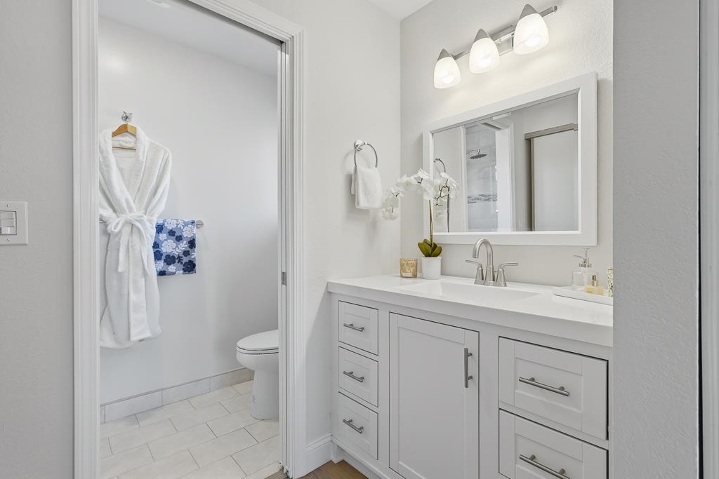 11868 Bloomington Way Dublin, CA 94568 - Photo 46 of 59 a bathroom with a granite countertop sink mirror and toilet