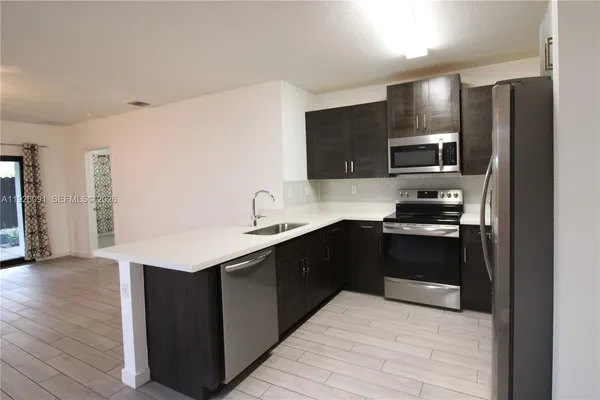 a kitchen with stainless steel appliances granite countertop a refrigerator and a sink
