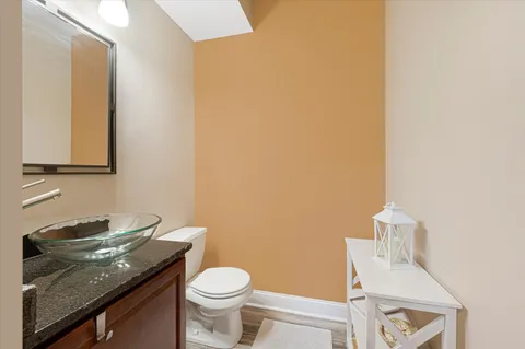 a bathroom with a granite countertop sink a toilet and a mirror