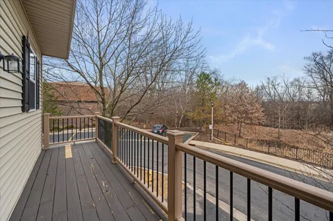 a view of a balcony with wooden floor and fence