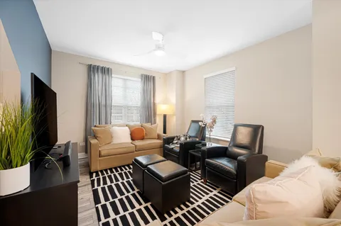 a living room with furniture a flat screen tv and a large window