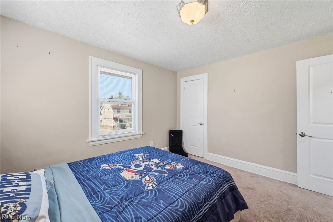 3386 Sylvanhurst Road Cleveland Heights, OH 44112 - Photo 22 of 46 Bedroom featuring a single window with white trim, light neutral wall color, and a textured ceiling