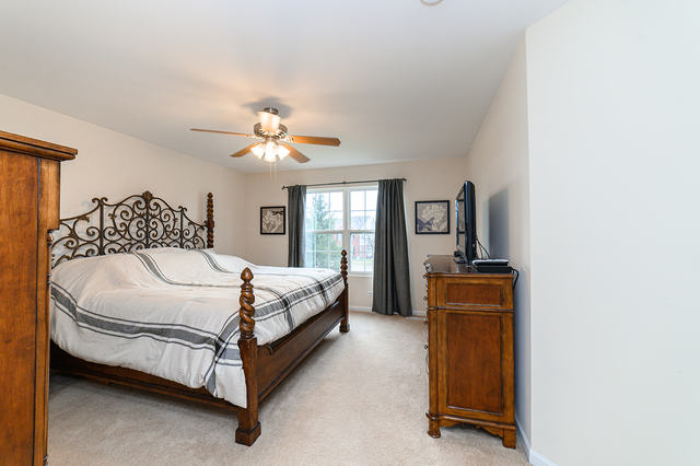 604 Springbrook Trail North Oswego, IL 60543 - Photo 12 of 22 a bedroom with a bed and a chandelier
