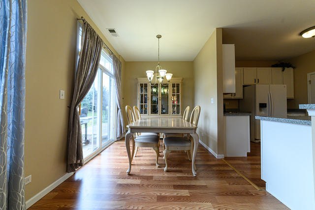 604 Springbrook Trail North Oswego, IL 60543 - Photo 9 of 22 a view of a dining room with furniture window and wooden floor