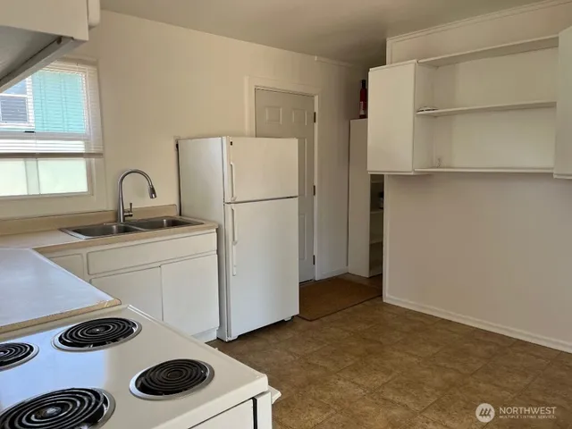 a view of a kitchen with stainless steel appliances granite countertop a stove and a sink