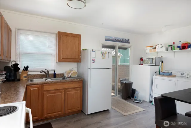a kitchen with a sink a refrigerator and cabinets