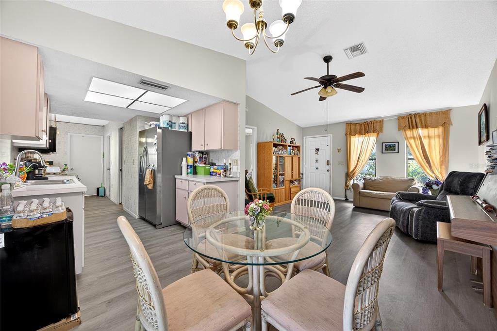 464 Coronado Road Venice, FL 34293 - Photo 7 of 28 a living room with furniture a fireplace and a chandelier