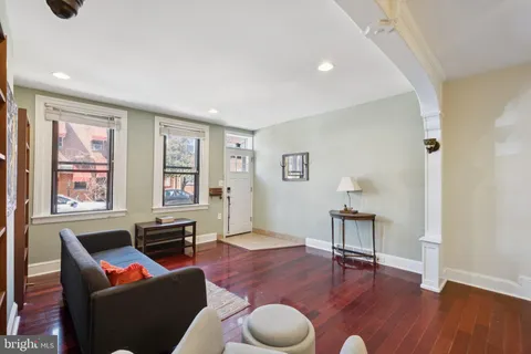 a living room with furniture a rug and a window