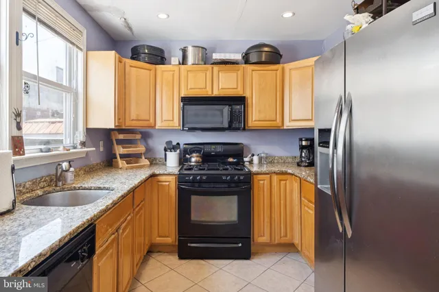a kitchen with stainless steel appliances granite countertop a stove a sink and a refrigerator