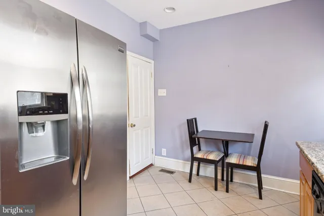 a view of a kitchen with refrigerator and table