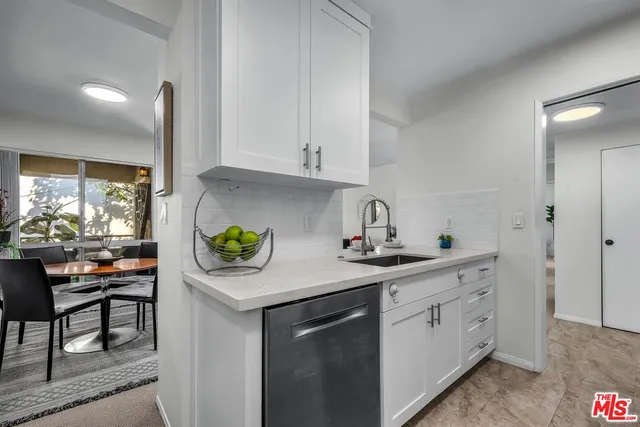 a kitchen with a white cabinets and window