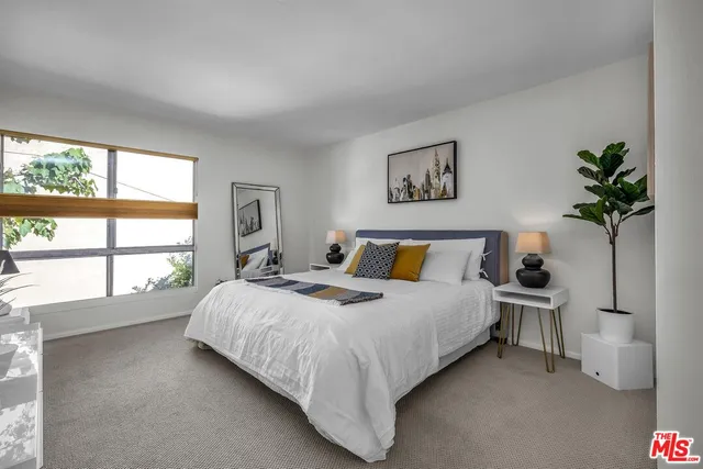 a bed sitting in a bedroom next to a window