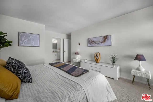 a bedroom with a large bed and a lamp