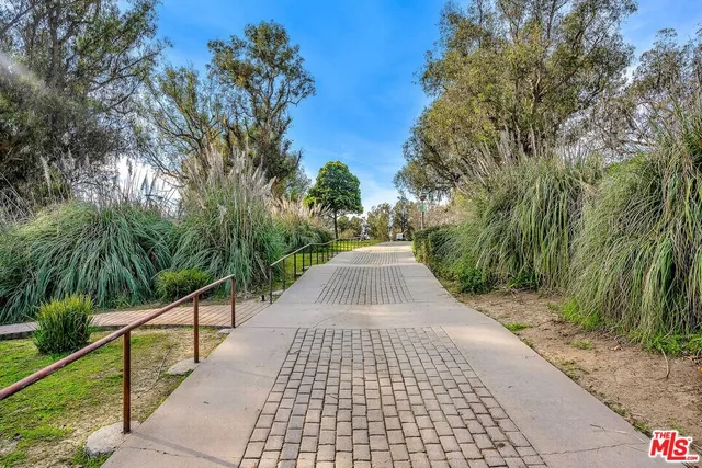 a view of a pathway with a wrought fence