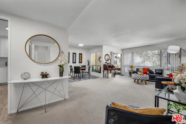 a living room with furniture a mirror and a large window
