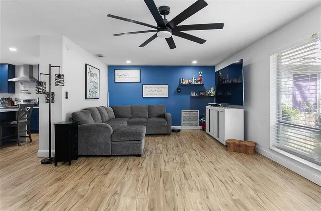 a living room with furniture and a wooden floor