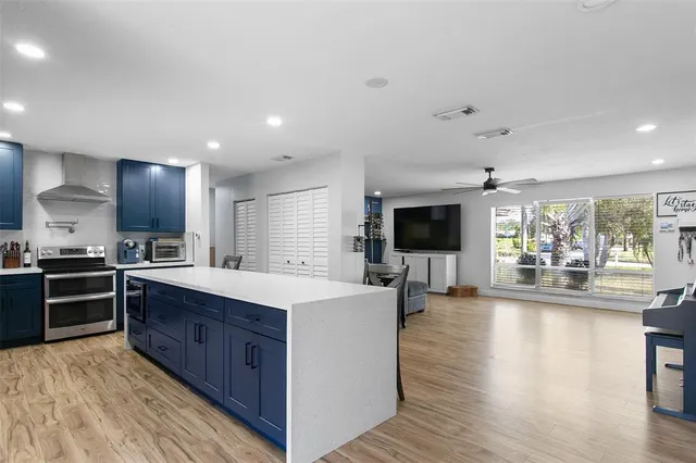 a large kitchen with stainless steel appliances lots of counter space and wooden floor