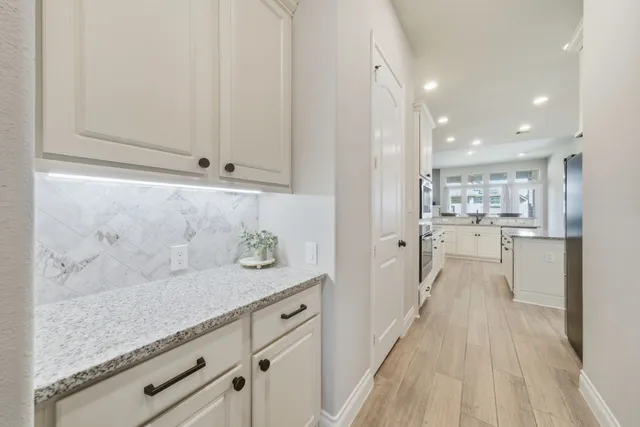 a view of a kitchen with kitchen island a counter top space a sink and stainless steel appliances