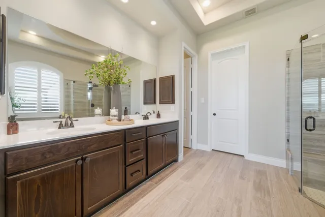 a bathroom with a double vanity sink and mirror with shower