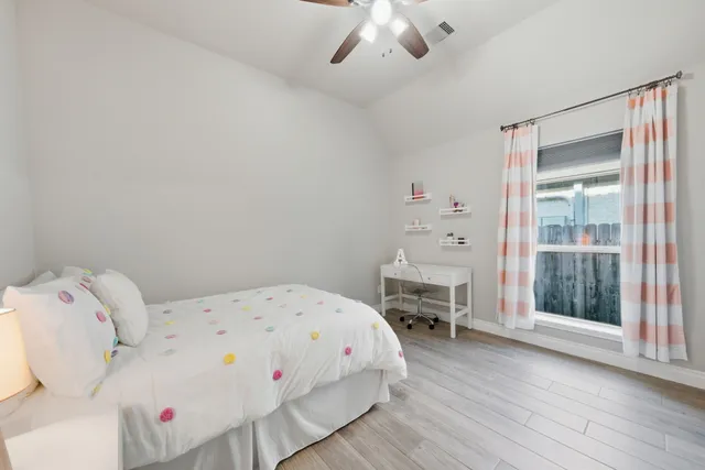 a white bed sitting in a bedroom next to a window