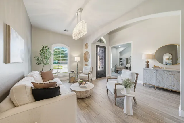 a living room with furniture a wooden floor and a chandelier