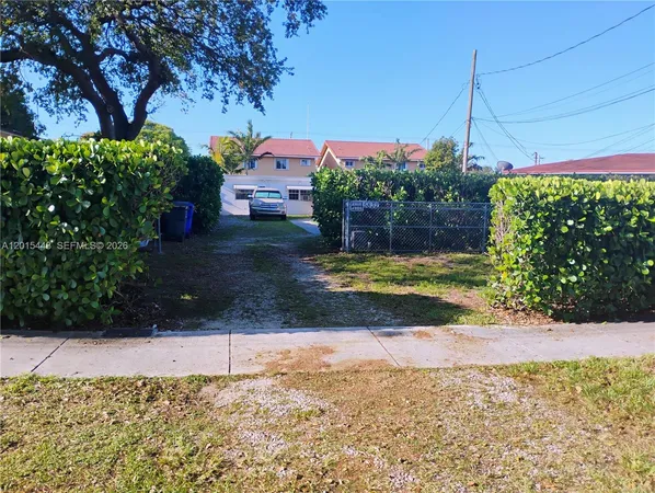 a view of a house with a yard and potted plants